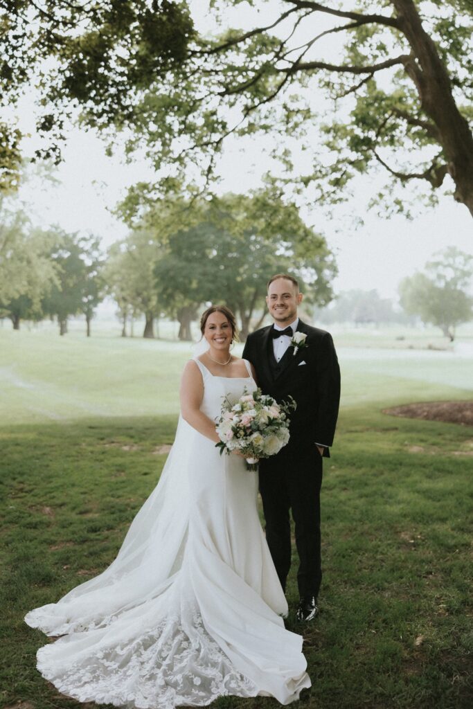 A bride and groom smile during their wedding portraits at their Chicago suburbs wedding venue the Chevy Chase Country Club. 