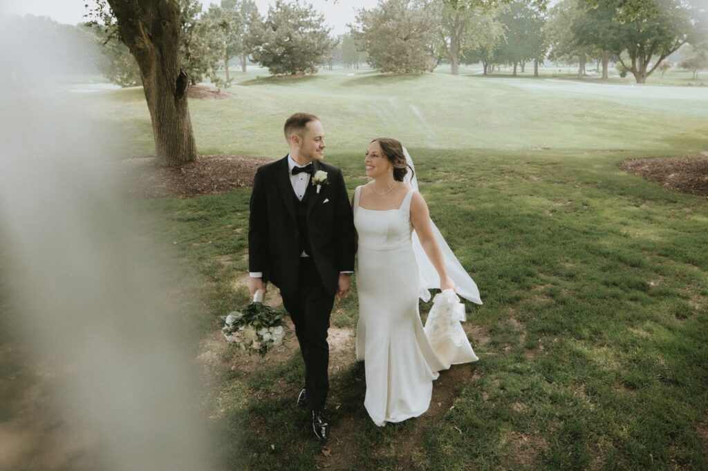A bride and groom walk towards the camera on their wedding day at their Chicago suburbs wedding venue. 