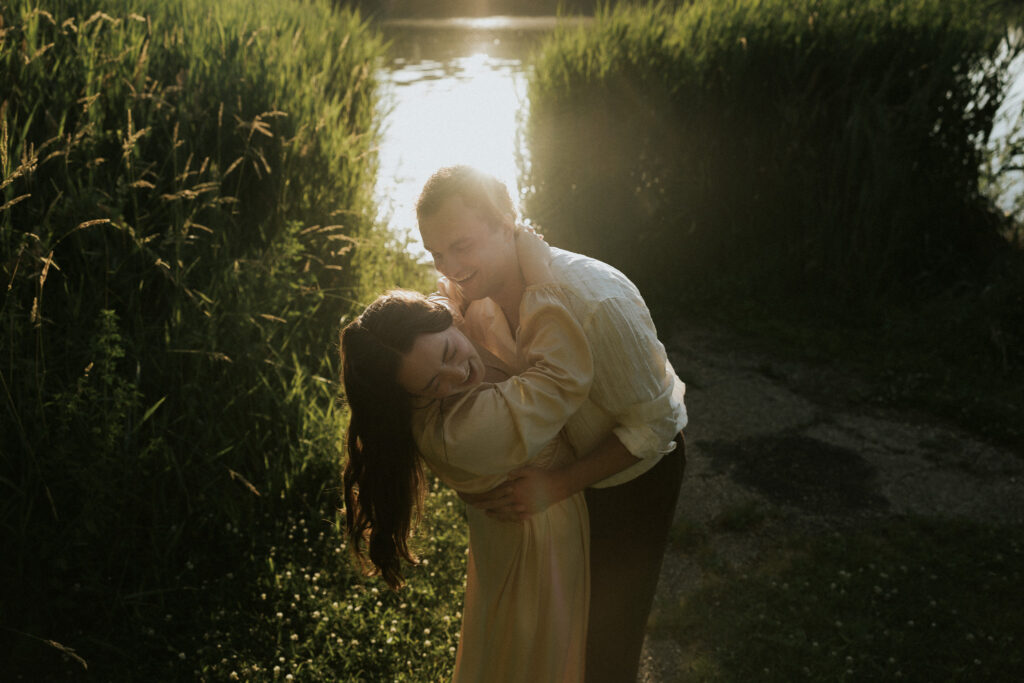 couple laughing during golden hour engagement session in bloomington, IL