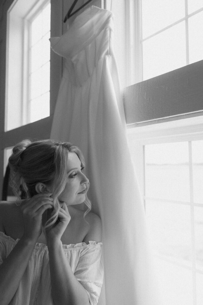 bride puts on earrings for her wedding at The Hilltop Barn, a new wedding venue in Central Illinois